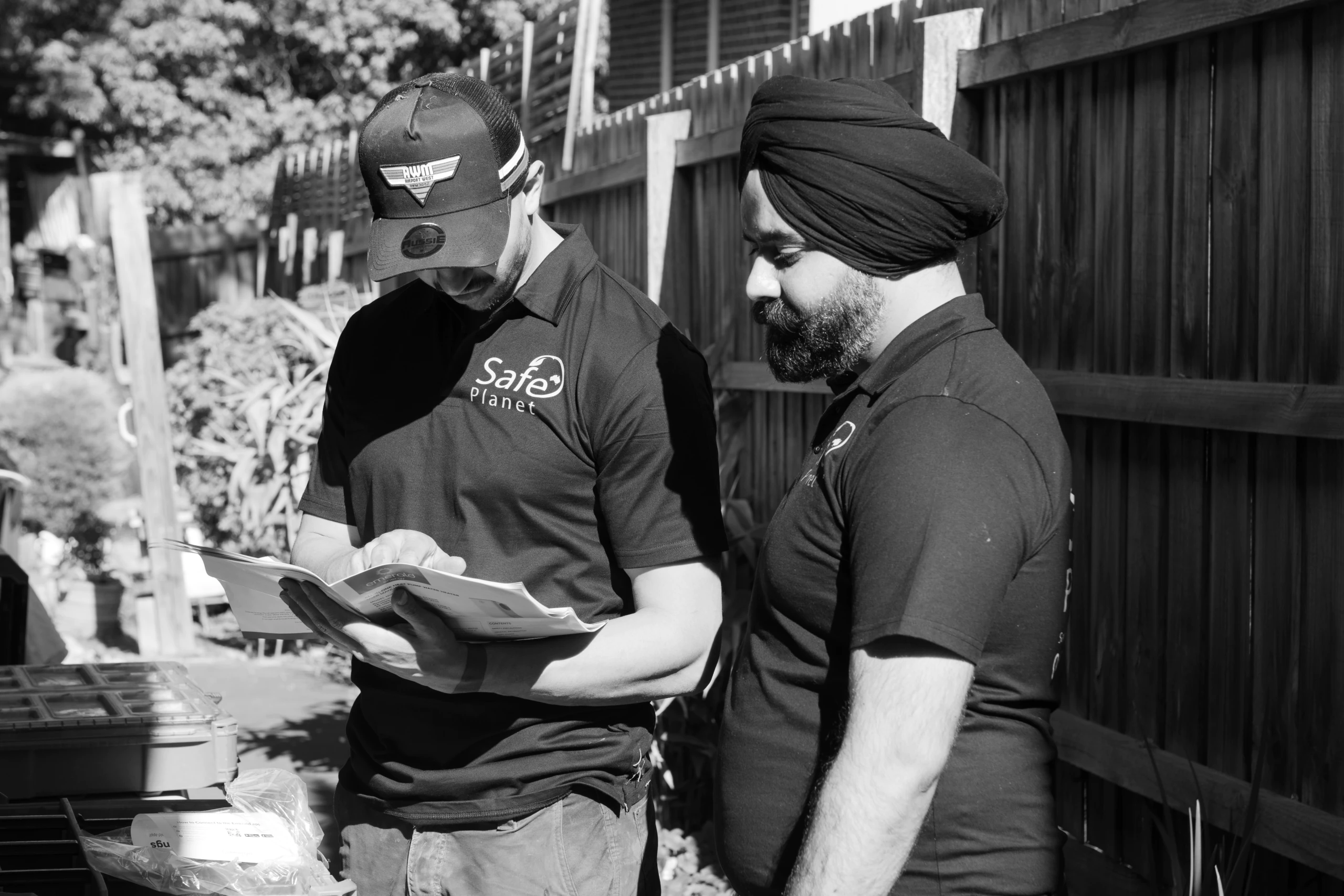 Two Safe Planet technicians discussing an installation plan at a home